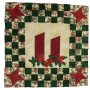 Two large Christmas candles for the centre piece to this wallhanging. The candles are underlined by sprigs of holly and framed by a checkerboard pattern with stars at the corners. The colours are predominantly green, red, cream and gold; Christmas colours.