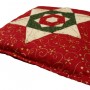 Shows the finished folded star cushion cover in place on a cushion.