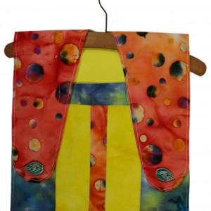 A very colourful peg-bag made from batik shown on a wooden clothes hanger. The main colours are orange , yellow and blue
