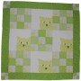 This is a brightly coloured quilt in shades of bright green which features the face of a really cute cat.
