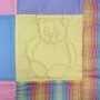 A detail of the squares and bears quilt showing one quilted panel which contains a bear.