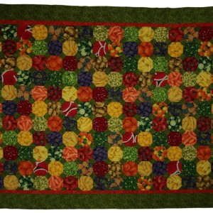 Shows a brightly coloured tablecloth, red, orange, yellow blue and green. It can also be quilted.