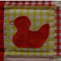 A single duckling on a yellow gingham background.