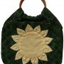 A useful and elegant quilted bag in green and yellow with wooden handles.